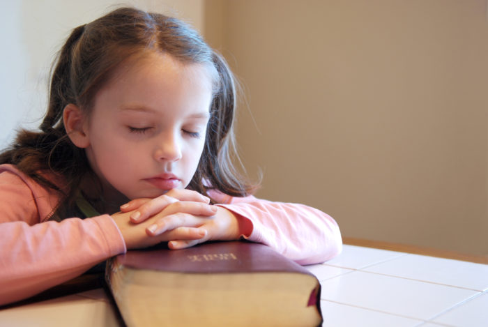 girl praying over bible