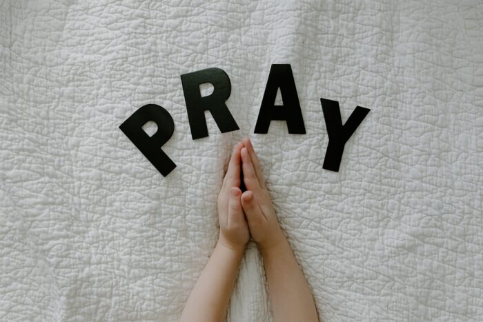 child's hands together in prayer